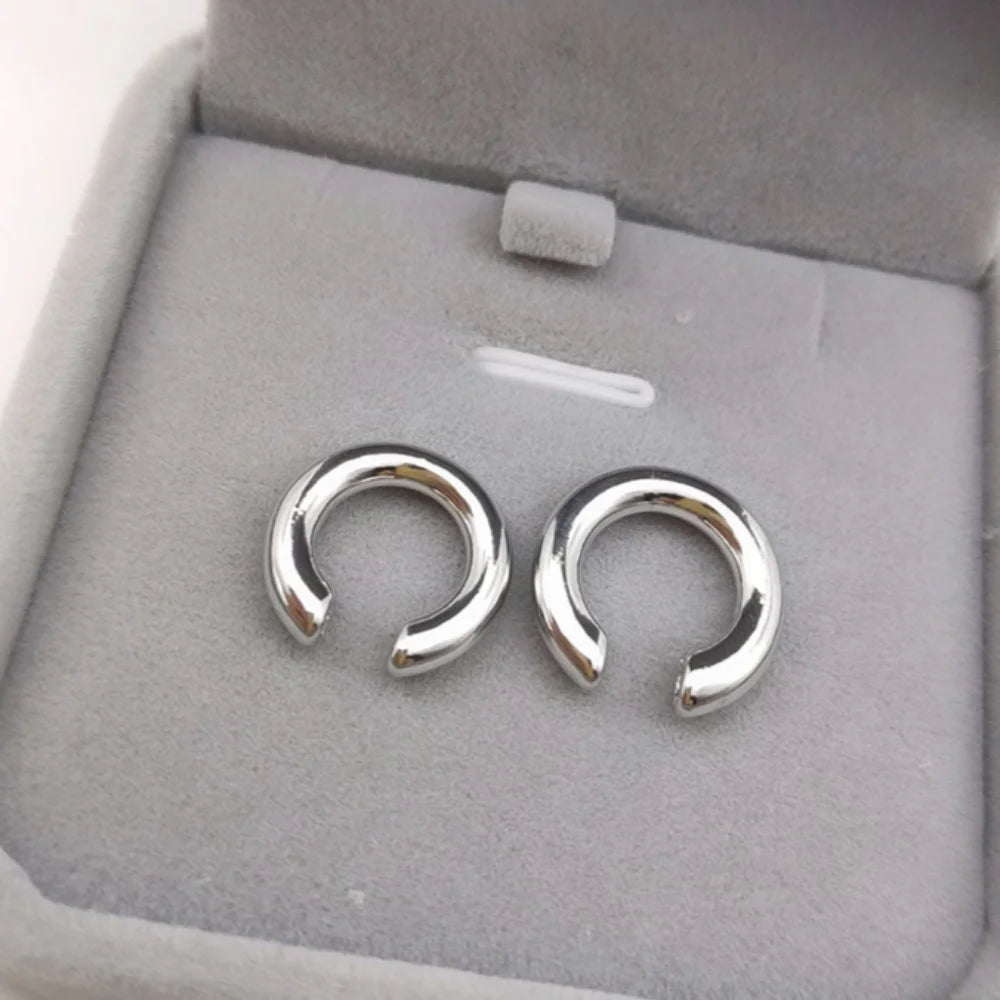 Add a touch of modern elegance with these minimalist gold ear cuffs. Designed in a sleek C-shape geometric style, they clip comfortably onto the ear—no piercing needed.