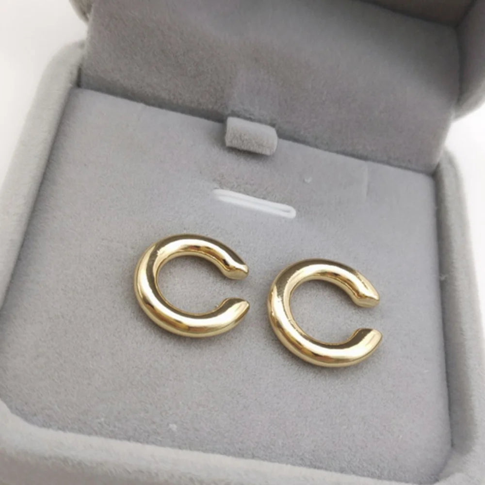Add a touch of modern elegance with these minimalist gold ear cuffs. Designed in a sleek C-shape geometric style, they clip comfortably onto the ear—no piercing needed.